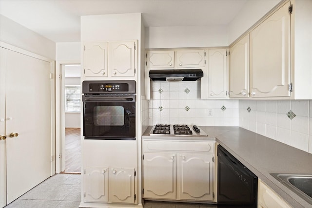 kitchen with black appliances, light tile patterned floors, sink, and tasteful backsplash