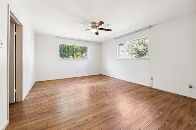 unfurnished bedroom featuring multiple windows, ceiling fan, and wood-type flooring