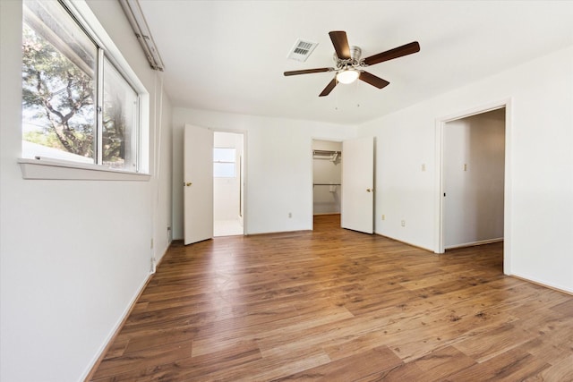 unfurnished room featuring hardwood / wood-style floors, a wealth of natural light, and ceiling fan