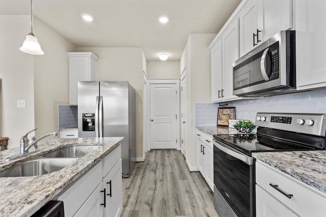 kitchen featuring sink, tasteful backsplash, decorative light fixtures, white cabinetry, and stainless steel appliances