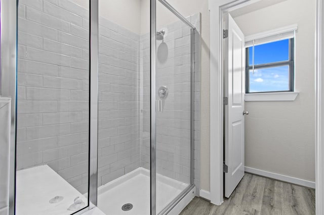 bathroom with a shower with door and hardwood / wood-style flooring