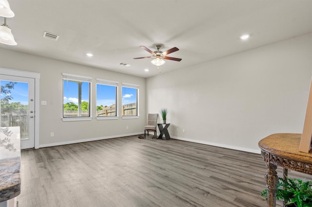 sitting room with ceiling fan and dark wood-type flooring