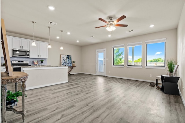 living room with ceiling fan and light wood-type flooring