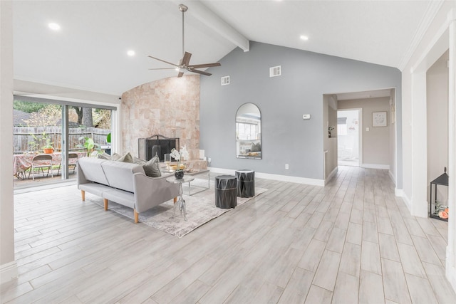 living room featuring ceiling fan, lofted ceiling with beams, light hardwood / wood-style floors, and a tile fireplace