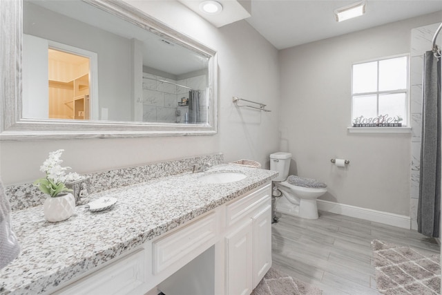 bathroom featuring curtained shower, vanity, and toilet