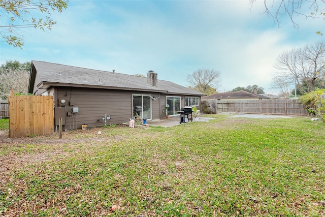 rear view of house featuring a yard and a patio