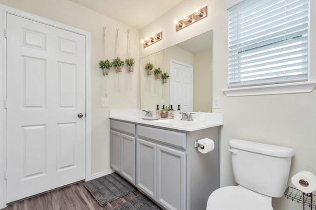 bathroom with hardwood / wood-style flooring, vanity, and toilet