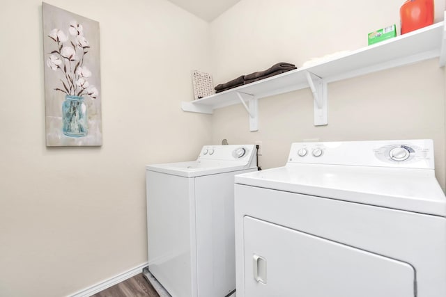 clothes washing area with separate washer and dryer and hardwood / wood-style floors