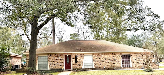 view of front of house with central AC and a front lawn