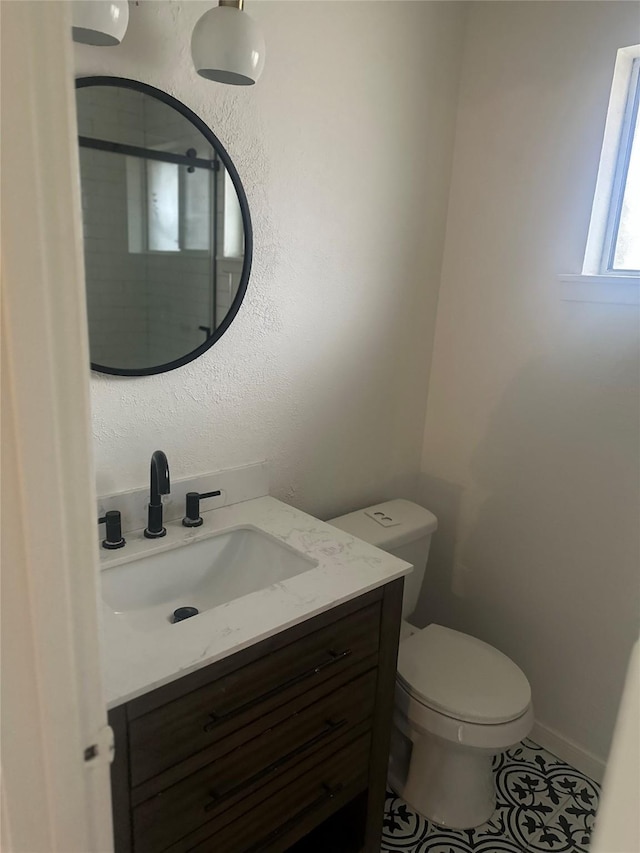 bathroom featuring tile patterned flooring, vanity, and toilet