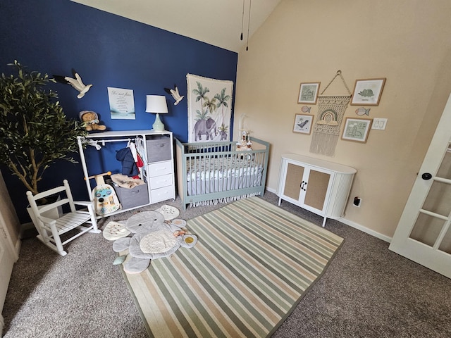 carpeted bedroom featuring a nursery area and lofted ceiling