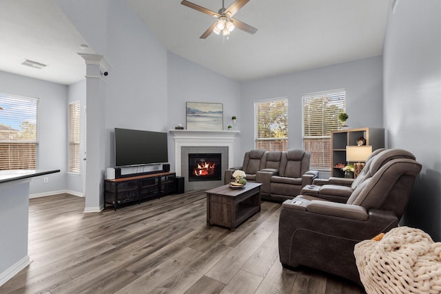 living room with a fireplace, ceiling fan, hardwood / wood-style floors, and lofted ceiling