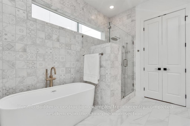 bathroom featuring shower with separate bathtub