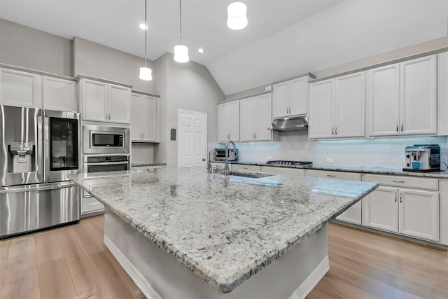 kitchen with backsplash, a center island with sink, and stainless steel appliances