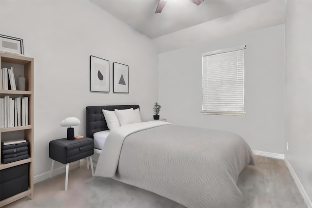 carpeted bedroom with ceiling fan and vaulted ceiling