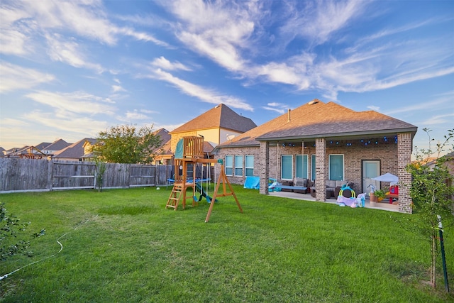 rear view of property featuring outdoor lounge area, a playground, a yard, and a patio