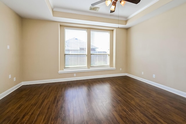 unfurnished room featuring a tray ceiling, crown molding, and dark hardwood / wood-style flooring