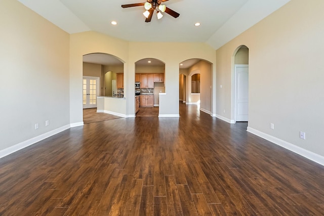 unfurnished living room with ceiling fan, dark wood-type flooring, and vaulted ceiling