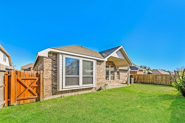 back of property featuring cooling unit and a yard