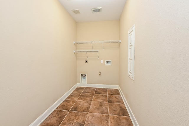 clothes washing area featuring electric dryer hookup, gas dryer hookup, washer hookup, and dark tile patterned flooring