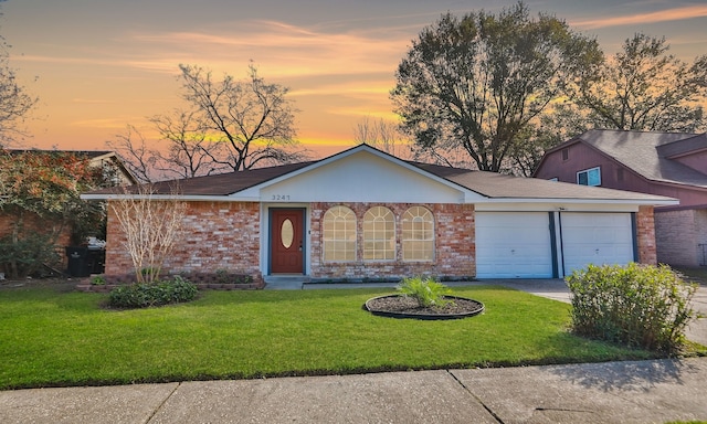 ranch-style home with a yard and a garage