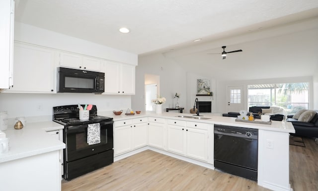 kitchen featuring kitchen peninsula, sink, black appliances, lofted ceiling with beams, and white cabinetry