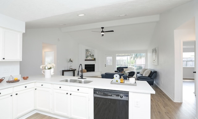 kitchen featuring kitchen peninsula, sink, black dishwasher, white cabinets, and vaulted ceiling with beams