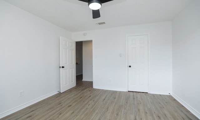 unfurnished bedroom featuring a closet, light hardwood / wood-style floors, and ceiling fan