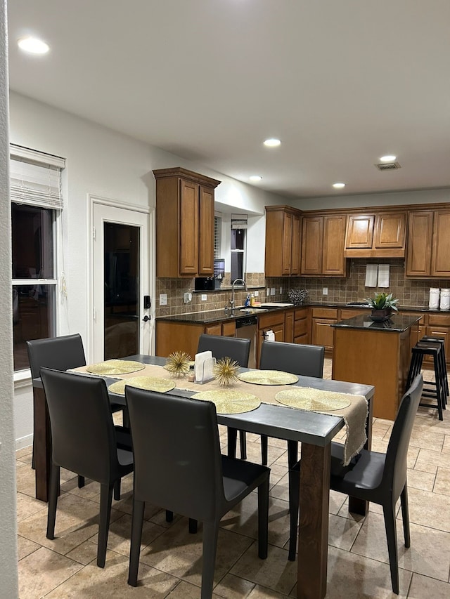 kitchen with backsplash, a kitchen island, and sink