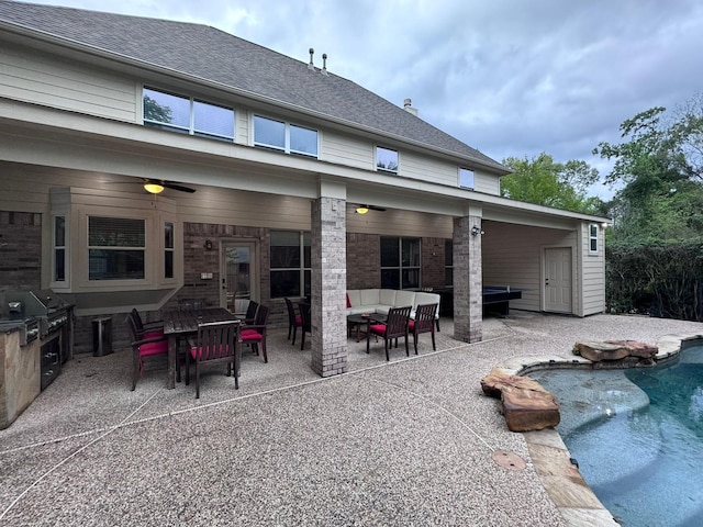 rear view of house featuring ceiling fan, exterior kitchen, an outdoor hangout area, a fenced in pool, and a patio