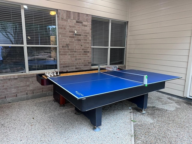 game room with wood walls and brick wall