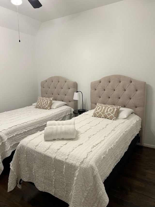 bedroom featuring ceiling fan, dark hardwood / wood-style flooring, and vaulted ceiling