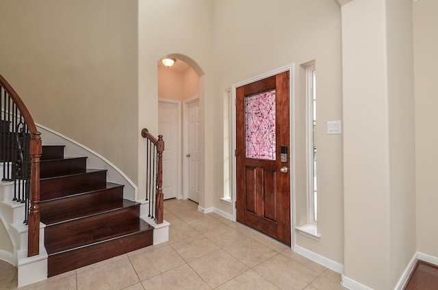 entrance foyer with light tile patterned flooring and a high ceiling