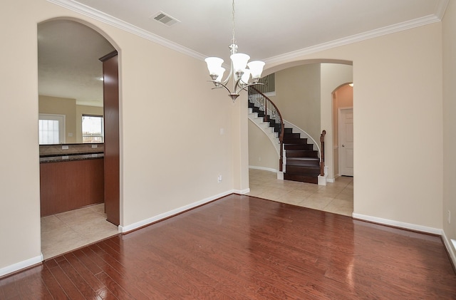 interior space with light hardwood / wood-style floors, ornamental molding, and an inviting chandelier