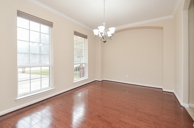 empty room featuring a notable chandelier, ornamental molding, and dark wood-type flooring