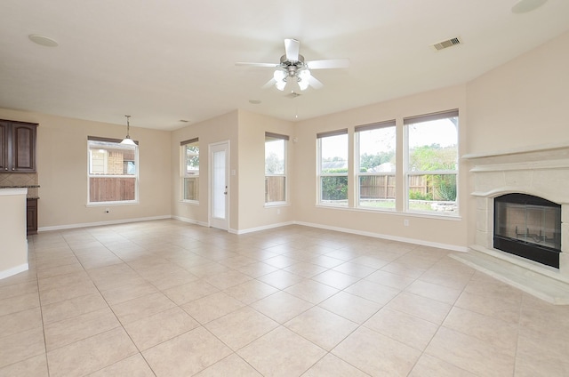 unfurnished living room featuring a fireplace, ceiling fan, and light tile patterned flooring