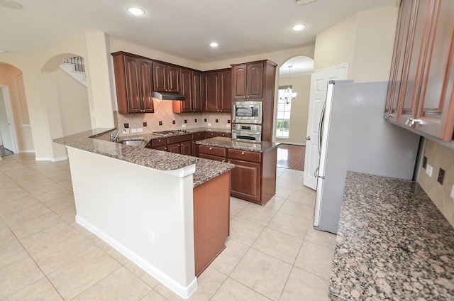 kitchen featuring kitchen peninsula, sink, light tile patterned floors, and stainless steel appliances