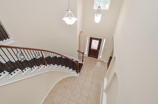 foyer entrance with light tile patterned floors and a high ceiling