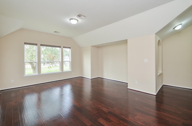 interior space with dark wood-type flooring and vaulted ceiling