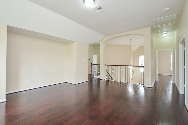 spare room featuring dark hardwood / wood-style flooring and vaulted ceiling