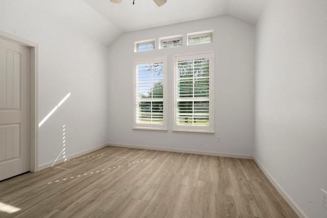 spare room with lofted ceiling, ceiling fan, and light wood-type flooring