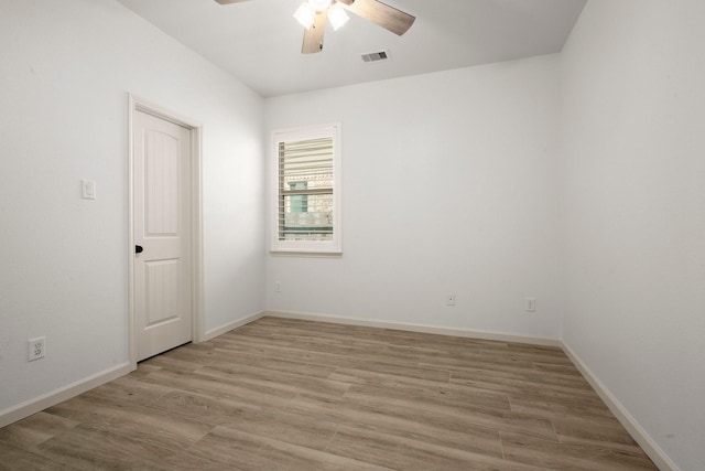 empty room with ceiling fan and light hardwood / wood-style flooring