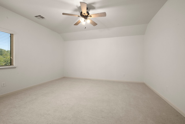 carpeted spare room with ceiling fan and vaulted ceiling