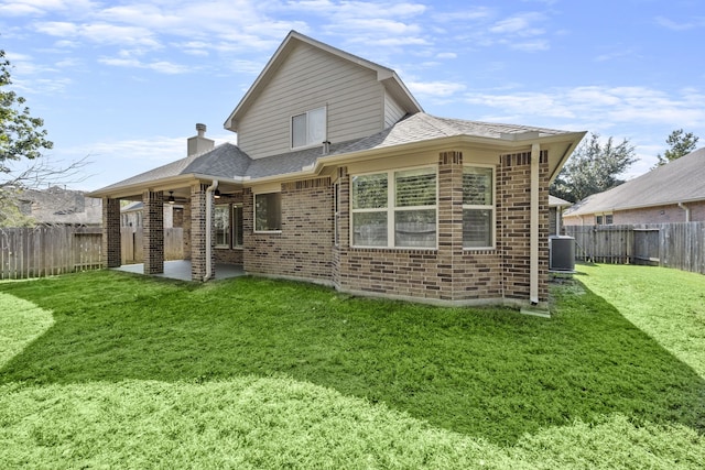 back of property with a lawn, cooling unit, and a patio area