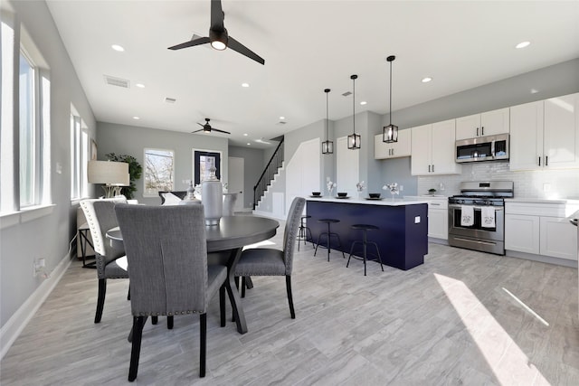 dining area featuring ceiling fan and light wood-type flooring