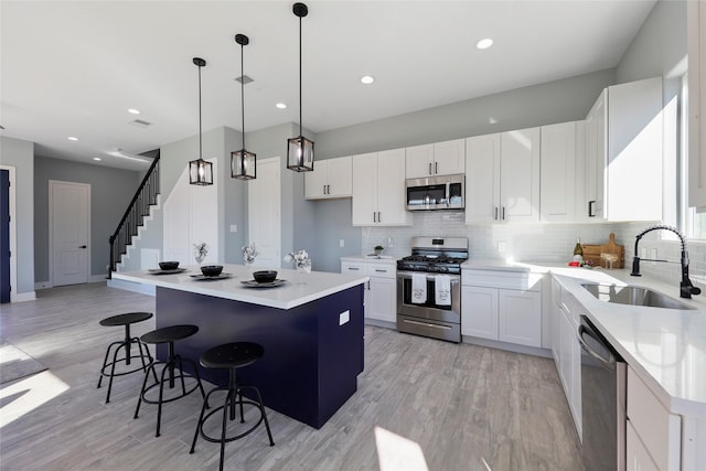 kitchen with white cabinetry, sink, a kitchen island, and appliances with stainless steel finishes