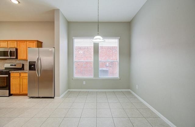 kitchen with decorative backsplash, light tile patterned floors, decorative light fixtures, and appliances with stainless steel finishes