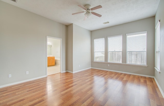 spare room with ceiling fan, light hardwood / wood-style floors, and a textured ceiling