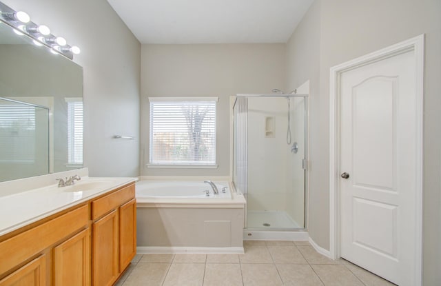 bathroom featuring plus walk in shower, vanity, and tile patterned floors