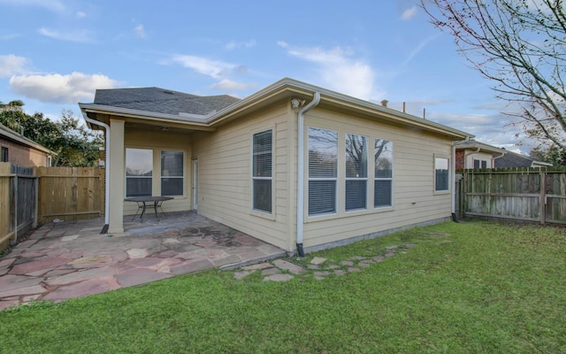 rear view of house with a patio area and a yard